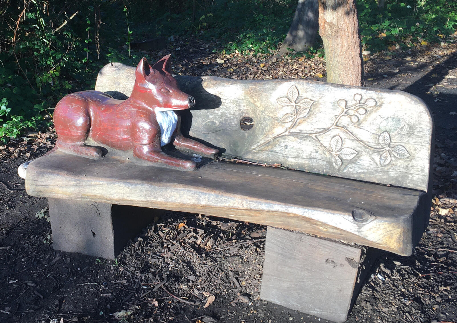 Two images show two wooden benches carved with decorative wildlife: one has birds and the other has a fox, which is painted.